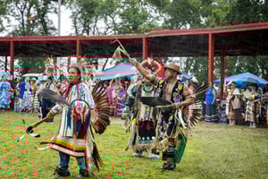 Native American dancers wearing traditional dress.